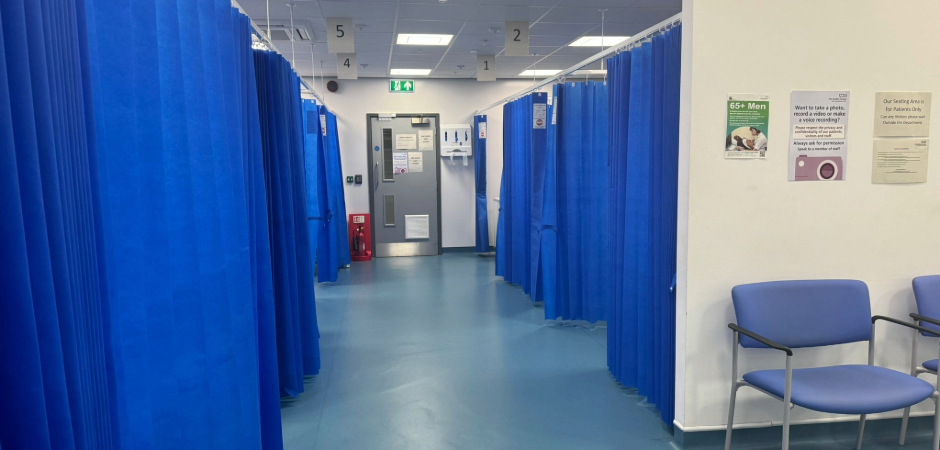a corridor with 5 blood test cubicles with blue curtains