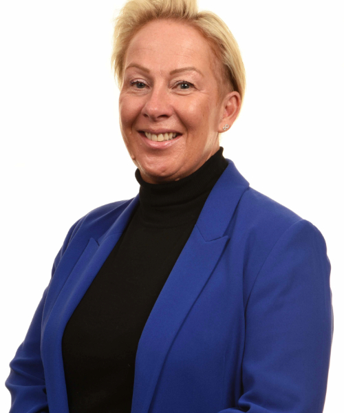 Headshot of Rachel Barlow - she is smiling at the camera, wearing a black polo neck and royal blue blazer